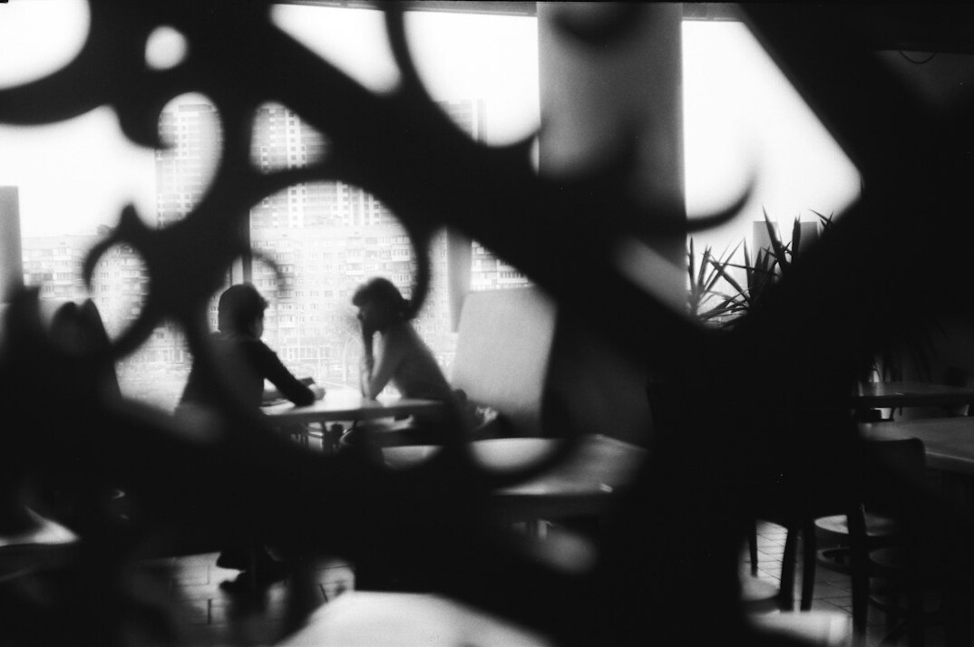 Diverse team of editors collaborating around a table with documents and laptops