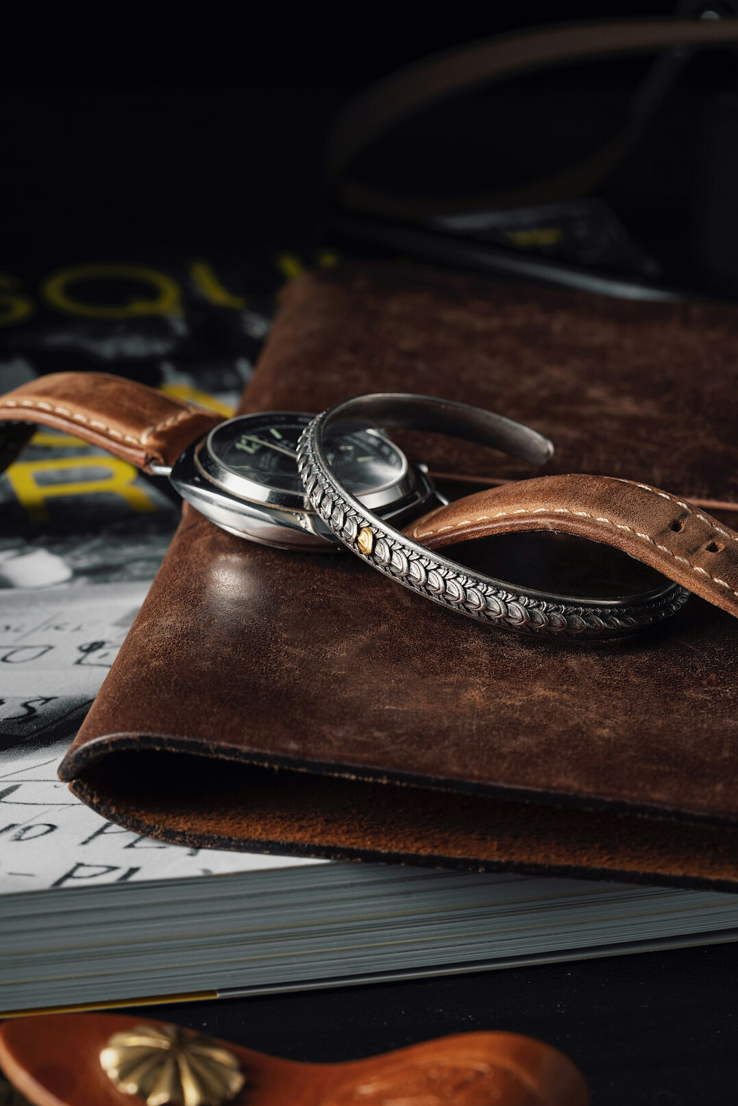 Detective notebook, magnifying glass and old map on a wooden desk under lamp light